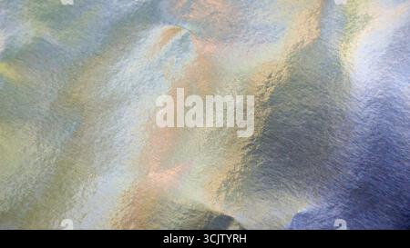 Iridescent silver foil paper texture, abstract festive background with pastel colors Stock Photo