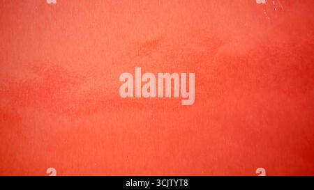 Shiny metallic red orange foil paper texture, abstract festive vibrant background Stock Photo