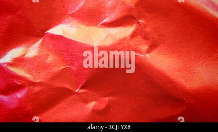 Crimson red metallic foil background, a crumpled and wrinkled paper texture Stock Photo
