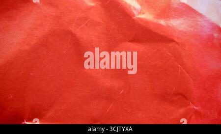 Crimson red metallic foil background, a crumpled and wrinkled paper texture Stock Photo
