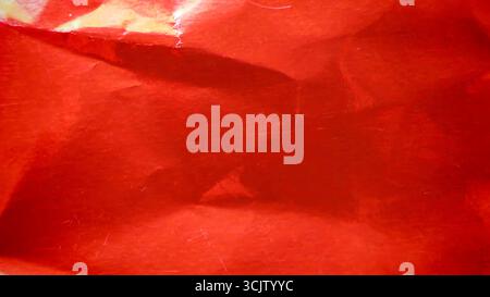 Crimson red metallic foil background, a crumpled and wrinkled paper texture Stock Photo