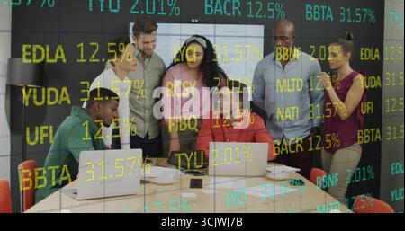 Collaborating team reviewing stock data on digital display in modern meeting room, with laptops Stock Photo
