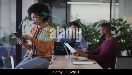 Using tablet woman collaborating with colleagues using laptop and documents in office, copy space Stock Photo