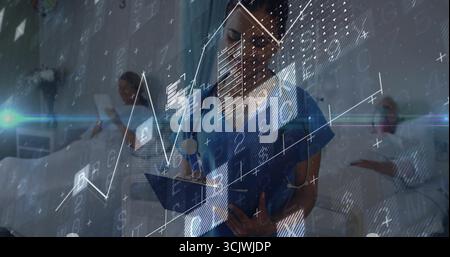 Nurse wearing stethoscope writing on clipboard in ward, with patients on beds using tablets, charts Stock Photo