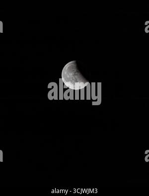 Aerial view of a crescent moon in the dark night sky, its pale surface illuminated against the inky blackness, Chania, Chania, Greece. Stock Photo
