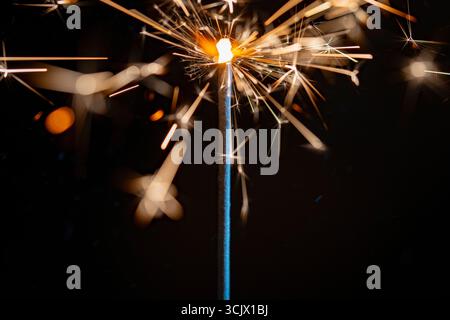 Burning sparkler on the black background, close up. Sparkler concept. Bengal lights on holiday party concept. New Year party sparkler Stock Photo