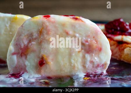 White mozzarella cheese served with raspberry jam and honey on a plate, close up Stock Photo