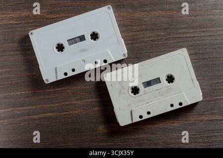 Two old vintage audio cassette on wooden background. Retro analog hi-fi music tape, close up, top view Stock Photo