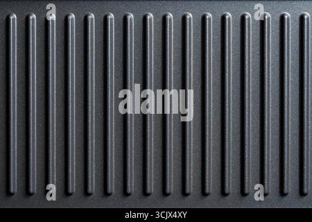 Black grill non-stick die-cast aluminum plates for design purpose, close up, top view. Electric grill plate as background or texture. ribbed striped g Stock Photo