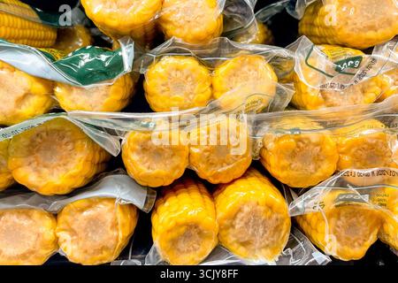 Corn cobs pack in basket at the grocery store, fruits and vegetables are sold at the market Stock Photo