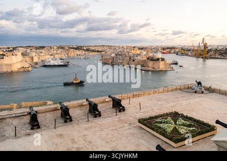 Beautiful sunset view of Valletta with a cannons in the foreground, capital city of Malta Stock Photo
