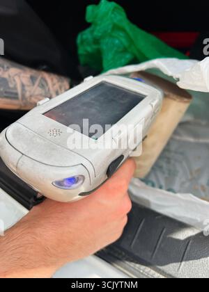 Gorodok, Ukraine - August 15, 2025: Close-up of XRF analyzer catalytic converter scanner in use, being held by a hand. Stock Photo