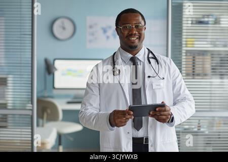 Portrait of Adult Black Man Doctor Smiling While Using Digital Tablet Stock Photo