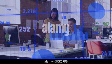 Data professionals in business attire reviewing data using laptop and monitors at office Stock Photo