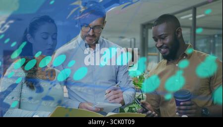 Collaborating trio analyzing data in modern open office with laptop, notebook and coffee cup Stock Photo