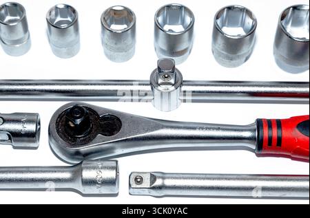 A set of new tools on a white background. Set of adjustable wrenches with handle holder, adapters and extensions and detachable sockets. Stock Photo