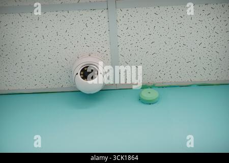 Security camera on the ceiling of the office. A surveillance camera. Stock Photo