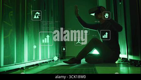 Interacting Korean tech wearing VR headset viewing CO2 metrics in server room, with floating icons Stock Photo