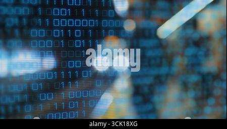 Displaying binary code overlay flickering on abstract interface, featuring rows of blue digits Stock Photo