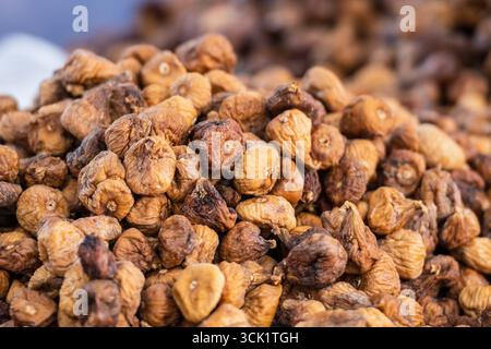 A close-up image of a large pile of dried figs, showcasing their textured, wrinkled skins and golden-brown tones Stock Photo