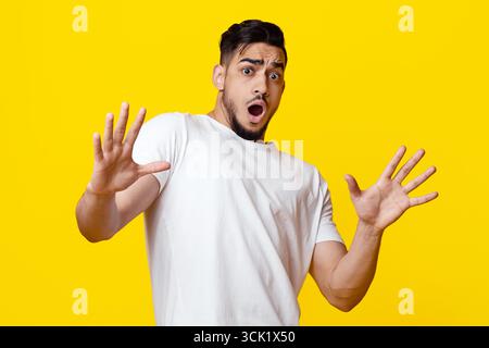 Scared arab guy in casual showing stop gesture Stock Photo