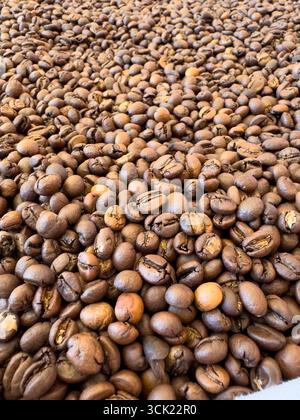 A rich, macro-level view of freshly roasted coffee beans. This image captures the texture and deep, warm colors of the beans, evoking the powerful aro Stock Photo