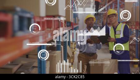 Checking workers wearing safety gear reviewing inventory on tablets in warehouse, with racks, boxes Stock Photo