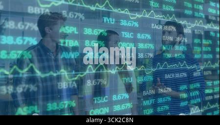Group of three analysts analyzing stocks on transparent display at trading floor with smartphone Stock Photo