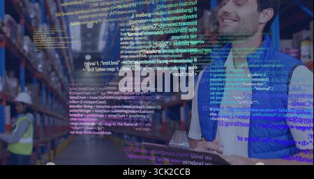 Checking male warehouse worker wearing vest holding clipboard and pen in aisle, with code overlay Stock Photo