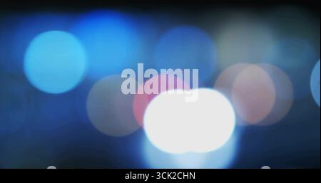 Displaying abstract bokeh pattern shimmering across dark background, with colorful circular lights Stock Photo