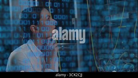 Connecting cable woman IT tech wearing headphones beside network switch in server room, copy space Stock Photo