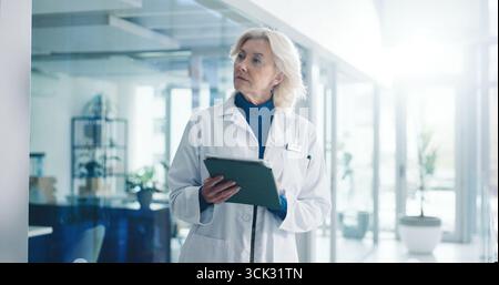 Tablet, mature woman and doctor in clinic with medical research, administration or communication. Digital technology, email and professional female Stock Photo