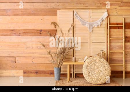 Interior of room with books on bench, pouf and folding screen Stock Photo