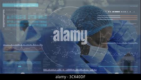 Standing surgeon in blue scrubs and masks operating in suite, with digital charts, brain overlays Stock Photo