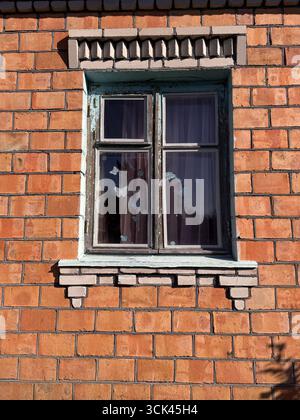 Window in a brick house. Dilapidated window frame. Stock Photo
