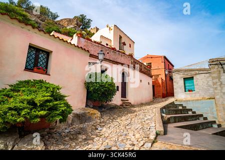 Historic cobblestone street with colorful old houses in Posada village, Sardinia Island, Italy Stock Photo