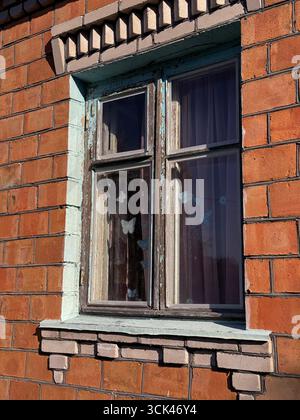 Window in a brick house. Dilapidated window frame. Stock Photo