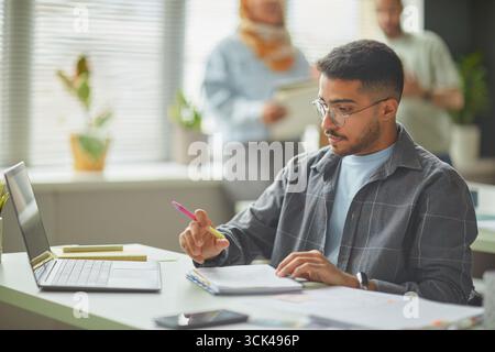 Young Adult Middle Eastern Man Studying Language at School Using Laptop Stock Photo