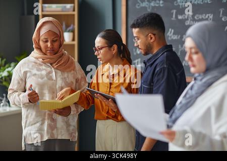 Multiethnic Young Adults Collaborating during Language School Group Activity Stock Photo