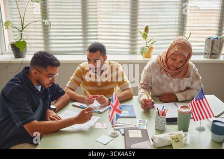 Young Adult Multiethnic Students Collaborating during Language School Lesson Stock Photo