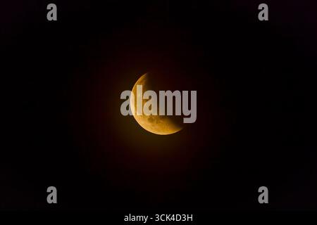 red full moon during the eclipse seen at half-coverage Stock Photo