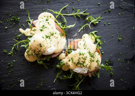 Overhead view of hollandaise sauce with eggs benedict breakfast on slate Image downloaded by at 20:45 on the 11/02/17 Stock Photo