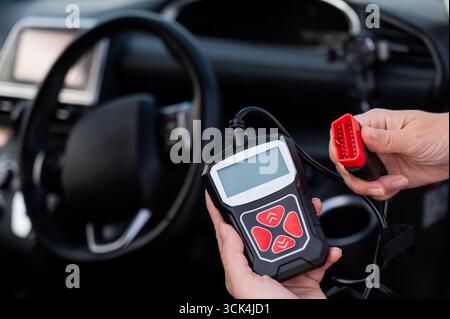 Woman using OBD2 diagnostic scanner.  Stock Photo