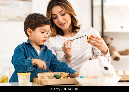 Mother and child colouring Easter eggs Stock Photo