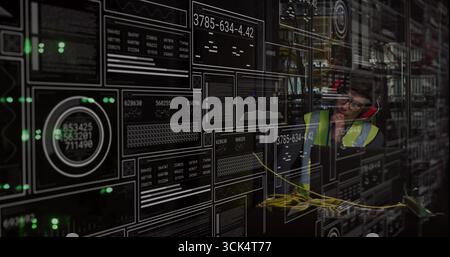 IT specialist wearing vest talking on phone while viewing panel in server room, copy space Stock Photo