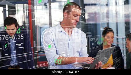 Collaborating data analysts wearing business attire typing on laptop and discussing data at office Stock Photo
