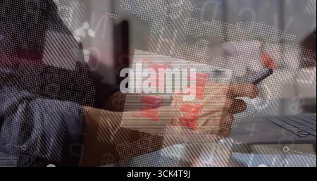 Business professional holding pen reviewing printed bar charts at office desk, with laptop overlays Stock Photo