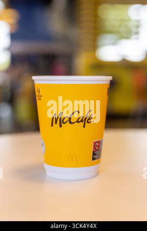 Kerpen, Germany - August, 9, 2025: Yellow McCafe coffee cup placed on table in McDonalds Stock Photo