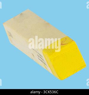 A yellow eraser with a rectangular shape, commonly used for correcting pencil marks on paper. Stock Photo