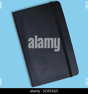 A closed black notebook with a textured cover and an elastic band, ideal for writing notes or sketches. Stock Photo